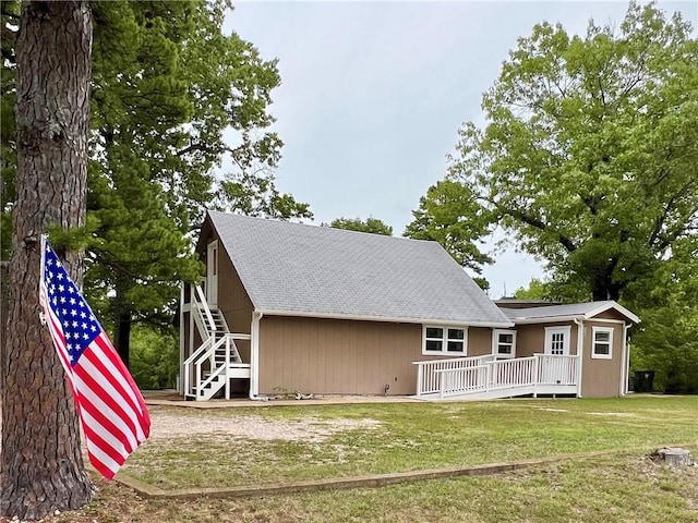 rear view of house featuring a yard and a deck