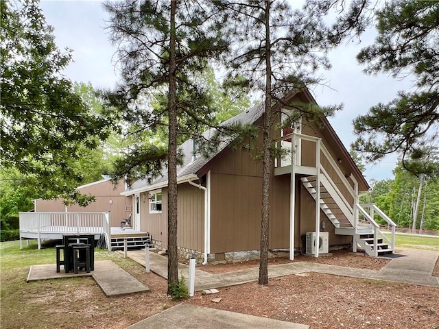 view of side of home featuring a wooden deck and ac unit