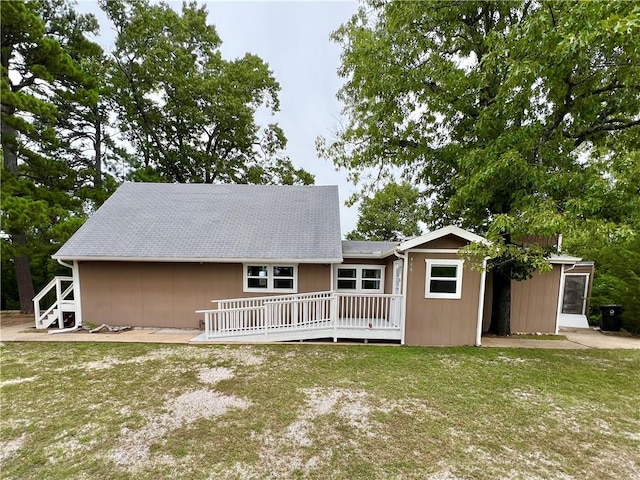 rear view of property featuring a wooden deck and a yard