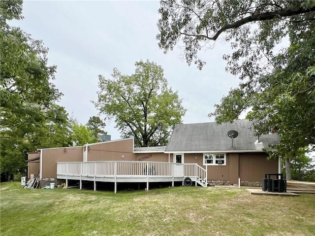 rear view of property featuring a lawn, a deck, and central air condition unit