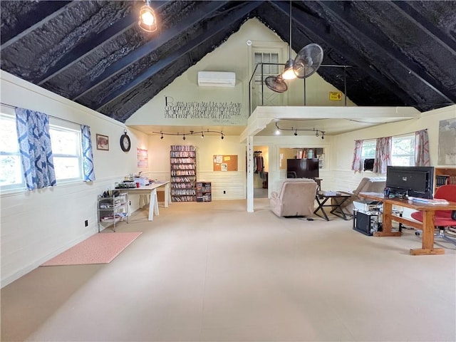 living room featuring a wall mounted air conditioner, a healthy amount of sunlight, rail lighting, and lofted ceiling