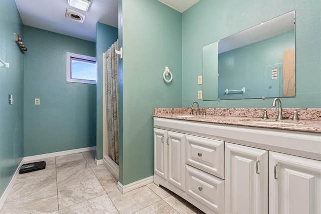 full bath featuring a shower with curtain, a sink, baseboards, and double vanity