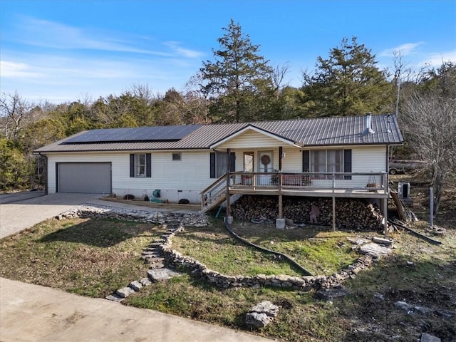 single story home with solar panels, stairway, an attached garage, metal roof, and driveway