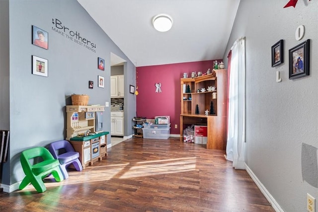 interior space with lofted ceiling, wood finished floors, and baseboards