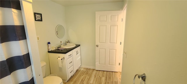 bathroom featuring vanity, wood-type flooring, and toilet