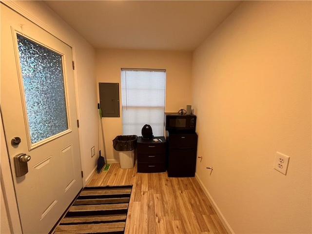 doorway with electric panel and light hardwood / wood-style flooring