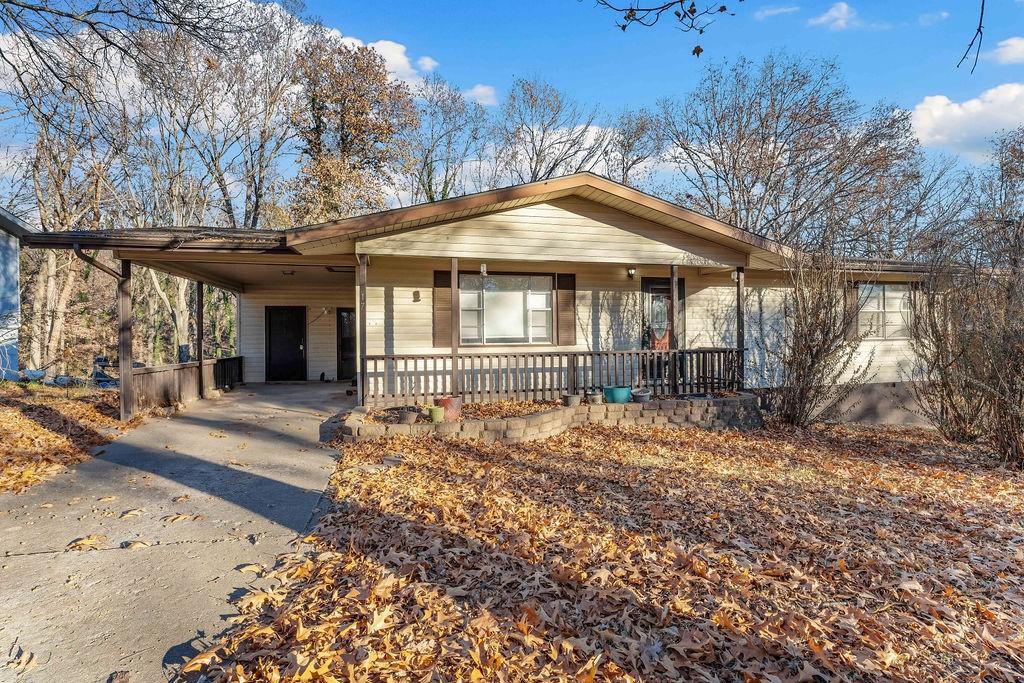 ranch-style house featuring a carport and covered porch