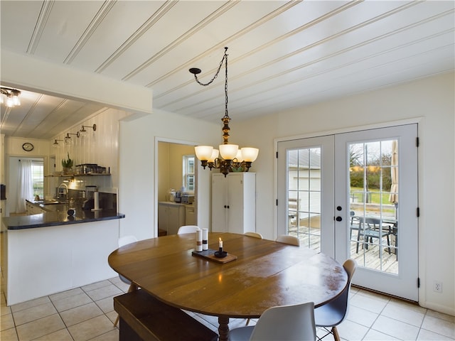 dining space with a chandelier, french doors, and light tile patterned floors