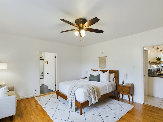 bedroom featuring ensuite bath, ceiling fan, and light hardwood / wood-style flooring