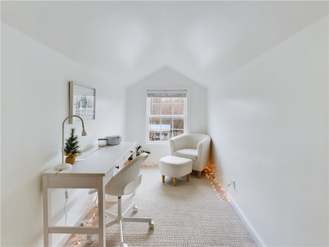 carpeted home office featuring vaulted ceiling