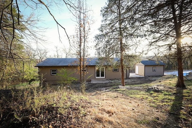 back of house with a shed