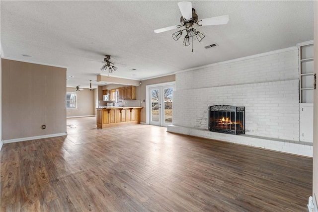 unfurnished living room with hardwood / wood-style flooring, plenty of natural light, and a textured ceiling