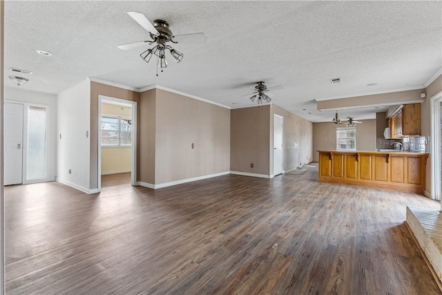 unfurnished living room featuring crown molding, wood-type flooring, and a textured ceiling