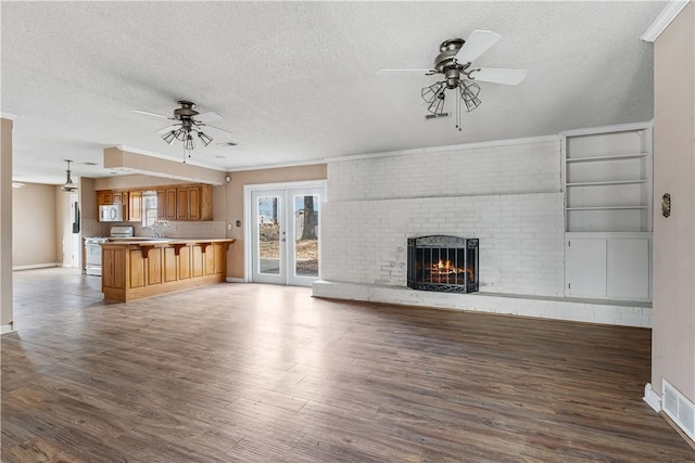 unfurnished living room with dark hardwood / wood-style flooring and a textured ceiling