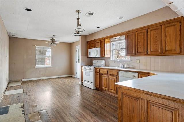 kitchen featuring ceiling fan, dark hardwood / wood-style floors, pendant lighting, a textured ceiling, and white appliances