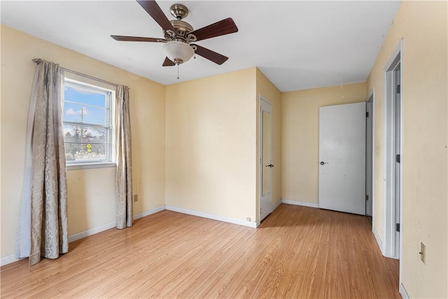 empty room with ceiling fan and light hardwood / wood-style flooring