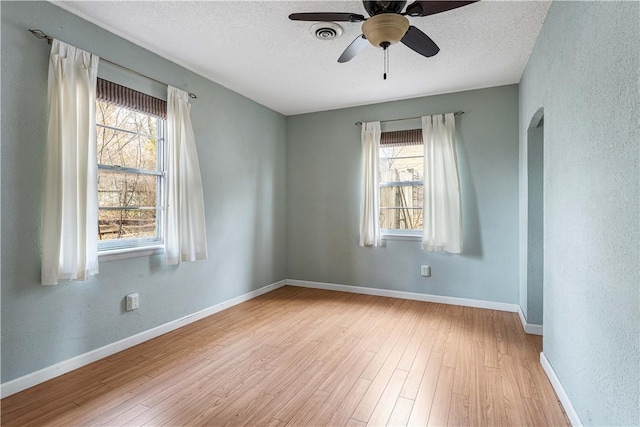 empty room featuring ceiling fan, light hardwood / wood-style floors, and a textured ceiling