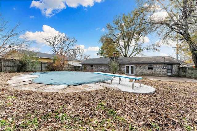 view of pool featuring a diving board, a patio area, and french doors