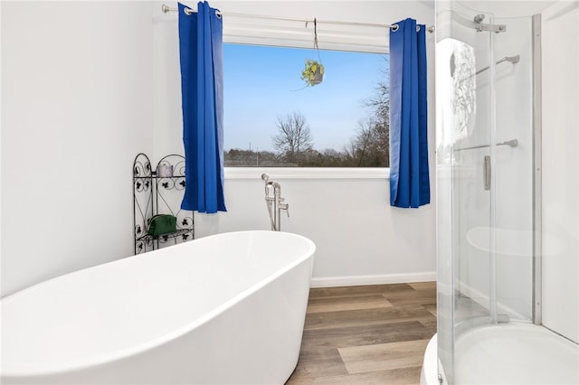 bathroom featuring hardwood / wood-style flooring, plenty of natural light, and separate shower and tub