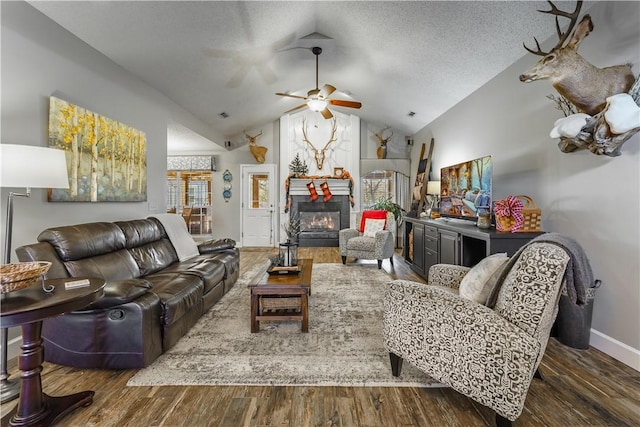 living room with a textured ceiling, dark hardwood / wood-style floors, ceiling fan, and lofted ceiling