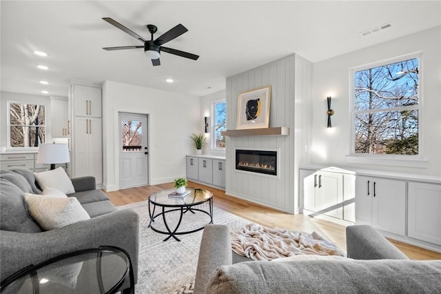 8893 Williams Rd, Rogers, AR 72756 - living room with light wood-style floors, plenty of natural light, a ceiling fan, a fireplace, and recessed lighting