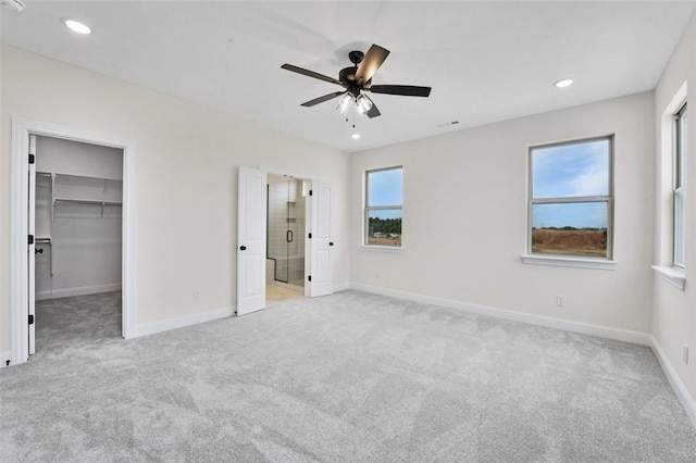 445 Fox Trl, Elm Springs, AR 72762 - unfurnished bedroom with a walk in closet, recessed lighting, and light colored carpet