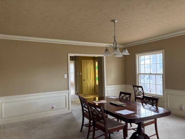 carpeted dining space featuring a notable chandelier, crown molding, and a textured ceiling