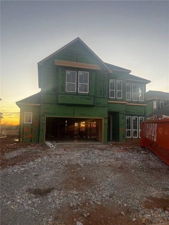 back house at dusk featuring a garage