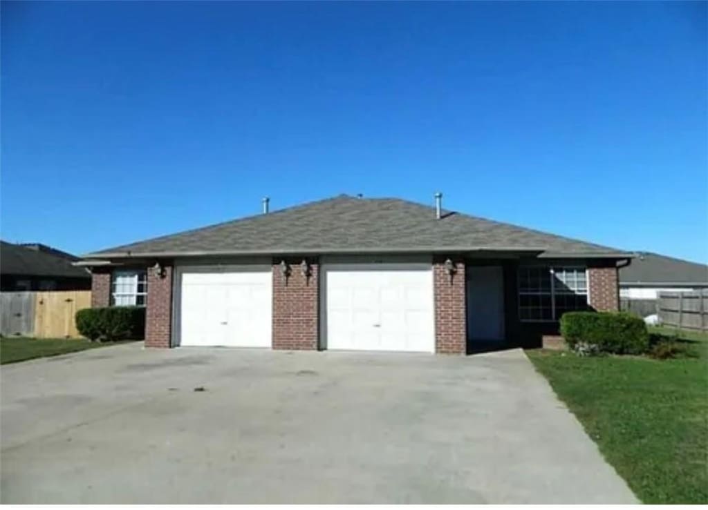 single story home featuring a front yard and a garage