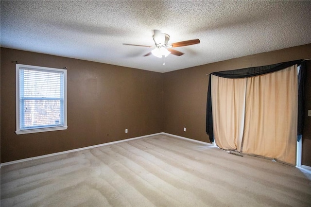 carpeted spare room featuring ceiling fan and a textured ceiling