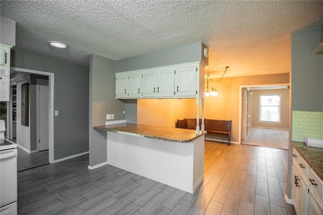 kitchen featuring white cabinetry, hardwood / wood-style floors, kitchen peninsula, and white range with electric stovetop