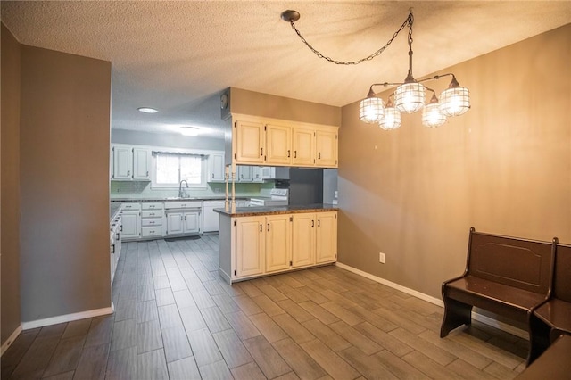 kitchen featuring white cabinetry, wood-type flooring, sink, hanging light fixtures, and kitchen peninsula