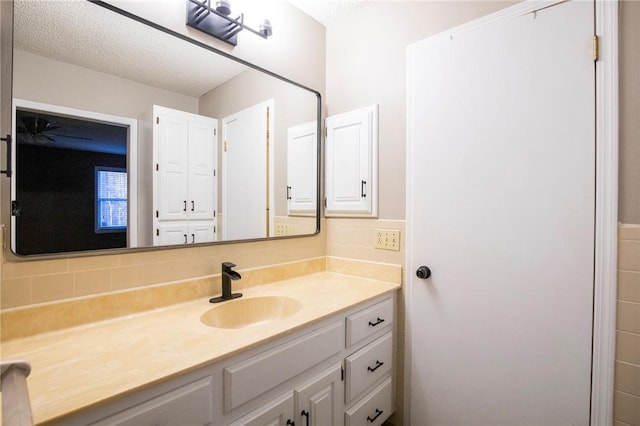 bathroom with vanity, a textured ceiling, and decorative backsplash