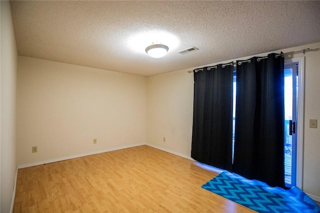 spare room with hardwood / wood-style floors and a textured ceiling