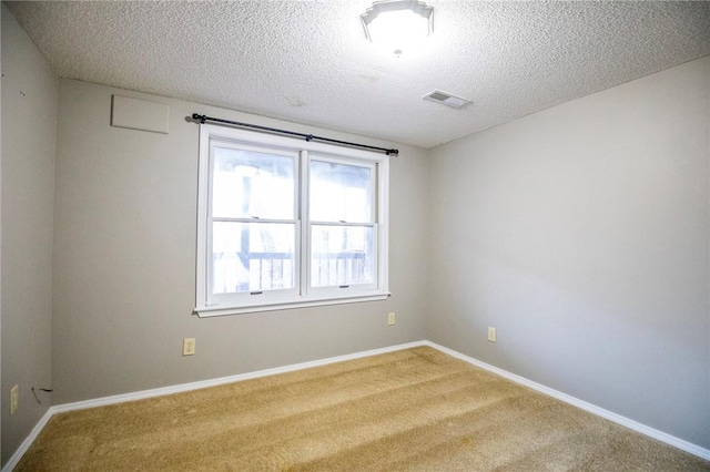 carpeted spare room with a textured ceiling