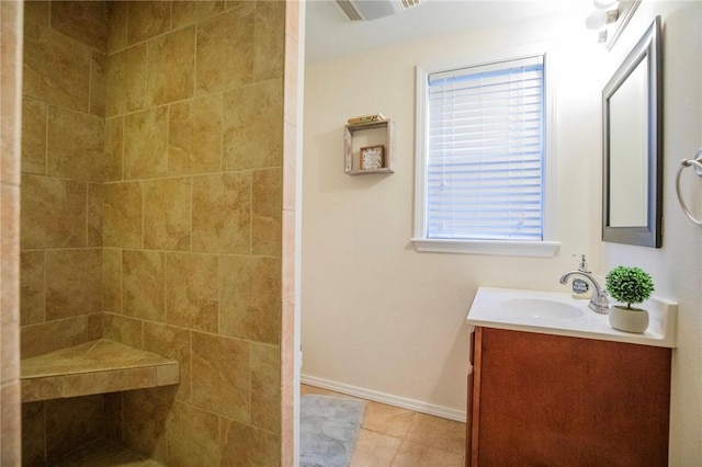 bathroom featuring tiled shower, vanity, and tile patterned flooring