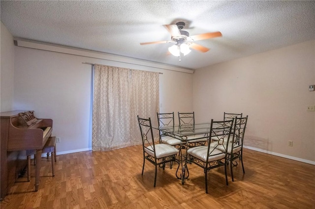 dining room featuring hardwood / wood-style flooring, a textured ceiling, and ceiling fan