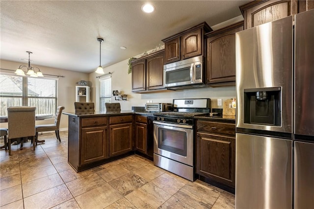 kitchen featuring dark brown cabinetry, kitchen peninsula, a chandelier, pendant lighting, and appliances with stainless steel finishes