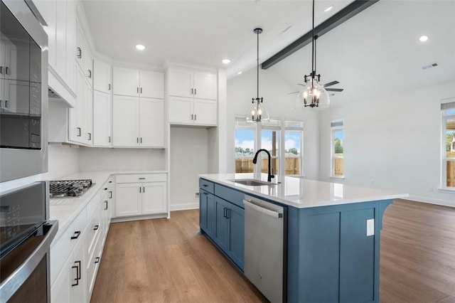 435 Fox Trl, Elm Springs, AR 72762 - kitchen with a sink, stainless steel appliances, blue cabinetry, light wood-style flooring, and white cabinets