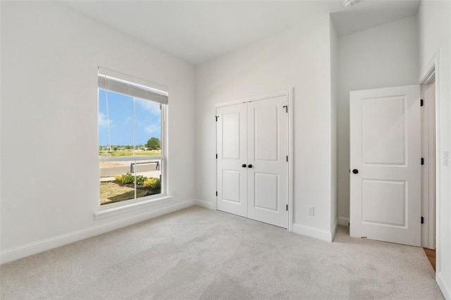 435 Fox Trl, Elm Springs, AR 72762 - unfurnished bedroom featuring light carpet, baseboards, and a closet