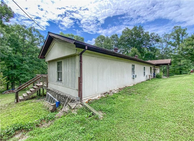 view of side of home featuring a lawn and cooling unit