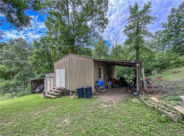 view of outdoor structure with a lawn and a carport