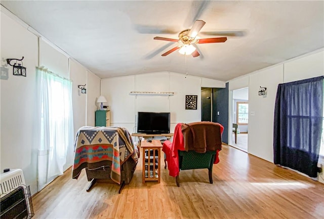 living room featuring hardwood / wood-style floors, heating unit, ceiling fan, and lofted ceiling