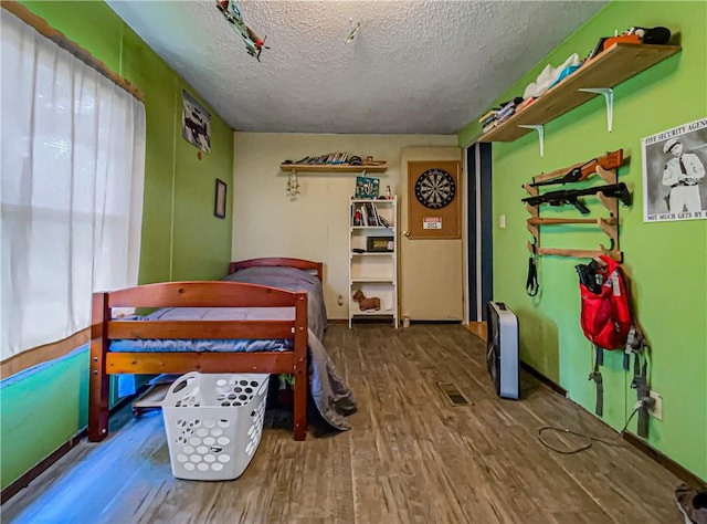 bedroom featuring hardwood / wood-style flooring and a textured ceiling