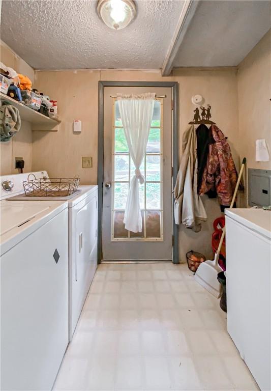 washroom with a textured ceiling and washing machine and clothes dryer