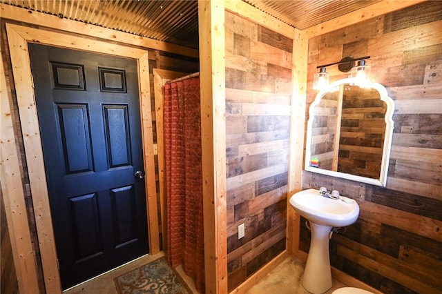 bathroom with a shower with curtain, wood ceiling, and wood walls