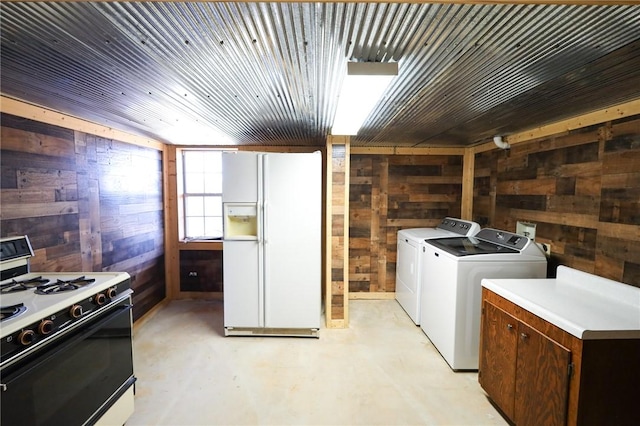 clothes washing area with separate washer and dryer, wooden walls, and wooden ceiling