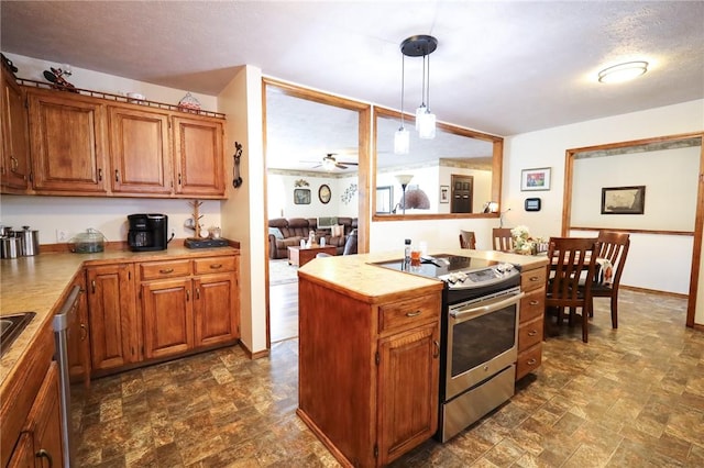 kitchen featuring stainless steel appliances, ceiling fan, pendant lighting, and a textured ceiling