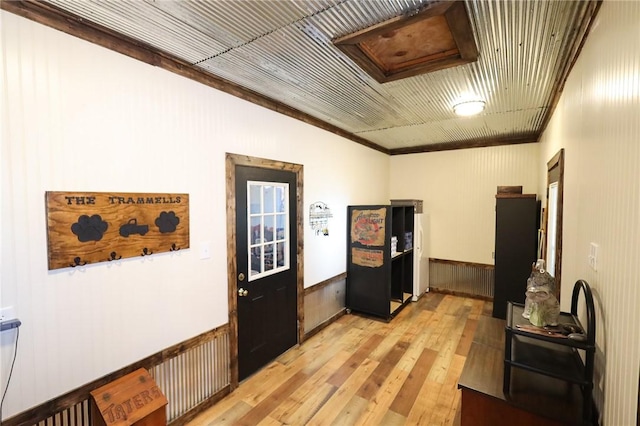 hallway featuring crown molding, light hardwood / wood-style floors, and wooden ceiling