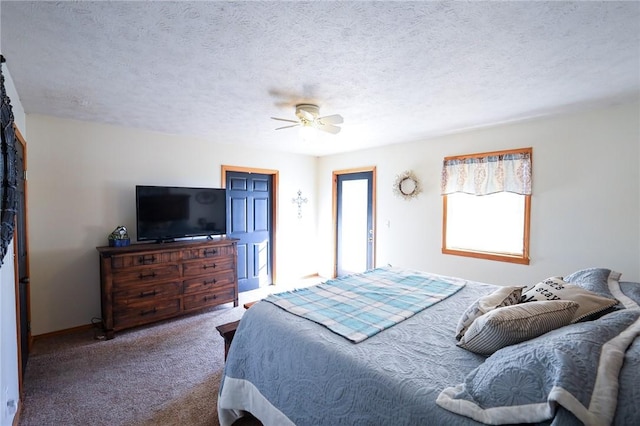 bedroom with ceiling fan, carpet floors, and a textured ceiling